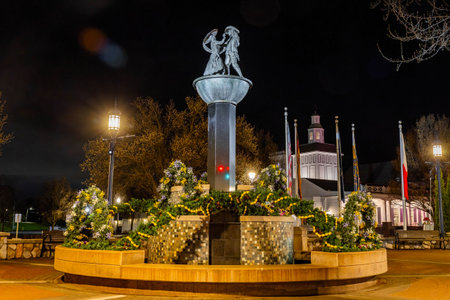 Photo of a Bavarian-style couples sculpture monument in Frankenmuth Michigan illuminated at night with warm lights and traditional charm.の写真素材
