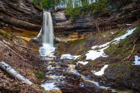 Photo of Munising Falls cascading down rock cliffs surrounded by forest at Pictured Rocks National Lakeshore in Michigan.の写真素材