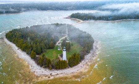 Dramatic aerial image of Cana Island Lighthouse in Wisconsin captured on a foggy day along Lake Michigan shorelineの写真素材