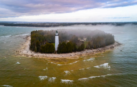 Dramatic aerial image of Cana Island Lighthouse in Wisconsin captured on a foggy day along Lake Michigan shorelineの写真素材
