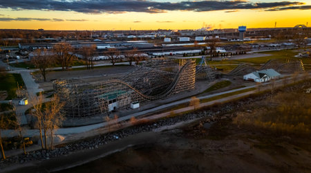 Aerial view over Bay Beach Amusement Park in Green Bay Wisconsin during sunset featuring roller coaster, Ferris wheel, and glowing sky.の写真素材