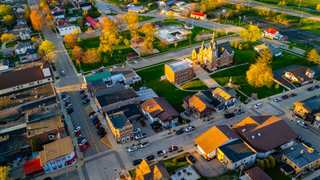 New Glarus Wisconsin at sunset showing city buildings, rooftops, and the Swiss United Church of Christ in golden light.の写真素材