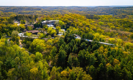 Aerial view of a forested landscape with a building complex, showing its dramatic architecture suspended above the landscapeの写真素材