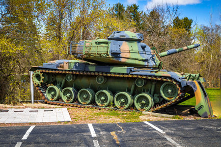 Detailed close-up view of a military tank showing its armored exterior, tracks, and turret, captured in strong daylight.の写真素材