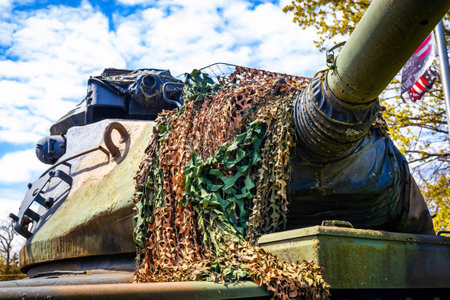 Detailed close-up view of an American military tank showing its armored exterior, tracks, and turret, captured in strong daylight.の写真素材