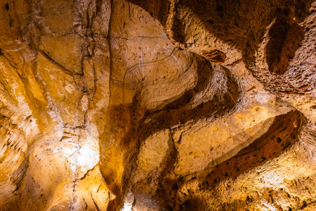 Scenic interior view of Cave of the Mounds in Wisconsin showing illuminated stalactites and stalagmites with dramatic lighting and no people visible.の写真素材