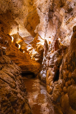 Scenic interior view of Cave of the Mounds in Wisconsin showing illuminated stalactites and stalagmites with dramatic lighting and no people visible.の写真素材
