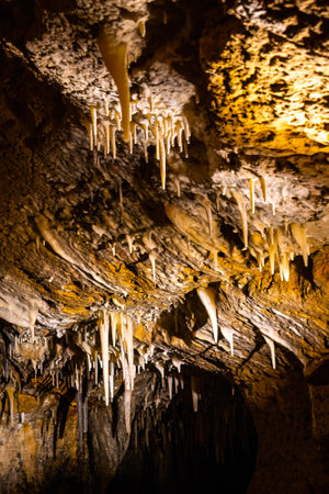 Scenic interior view of Cave of the Mounds in Wisconsin showing illuminated stalactites and stalagmites with dramatic lighting and no people visible.の写真素材
