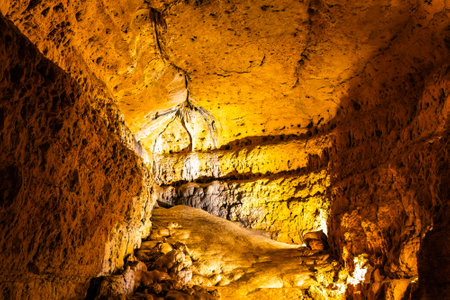 Scenic interior view of Cave of the Mounds in Wisconsin showing illuminated stalactites and stalagmites with dramatic lighting and no people visible.の写真素材
