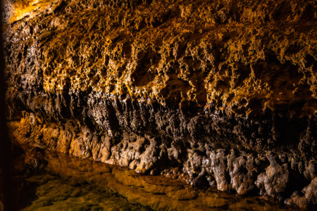 Scenic interior view of Cave of the Mounds in Wisconsin showing illuminated stalactites and stalagmites with dramatic lighting and no people visible.の写真素材
