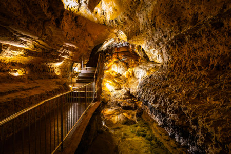 Scenic interior view of Cave of the Mounds in Wisconsin showing illuminated stalactites and stalagmites with dramatic lighting and no people visible.の写真素材