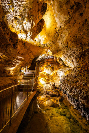 Scenic interior view of Cave of the Mounds in Wisconsin showing illuminated stalactites and stalagmites with dramatic lighting and no people visible.の写真素材