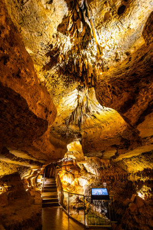 Scenic interior view of Cave of the Mounds in Wisconsin showing illuminated stalactites and stalagmites with dramatic lighting and no people visible.の写真素材