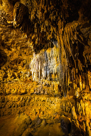 Scenic interior view of Cave of the Mounds in Wisconsin showing illuminated stalactites and stalagmites with dramatic lighting and no people visible.の写真素材