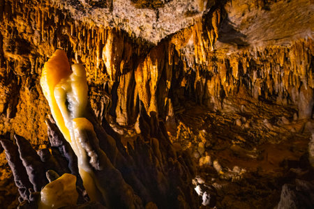 Scenic interior view of Cave of the Mounds in Wisconsin showing illuminated stalactites and stalagmites with dramatic lighting and no people visible.の写真素材