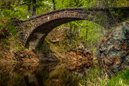 A picturesque view of Glensheen Mansion stone arch bridge spanning Tischer Creek as it flows into Lake Superior.の写真素材