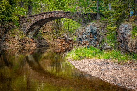 A picturesque view of a stone arch bridge spanning Tischer Creek as it flows into Lake Superior.の写真素材