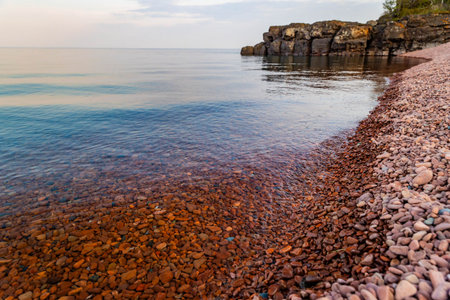 Captivating view of colored rocks and clear waters at Ionas Beach along the shore of Lake Superiorの写真素材