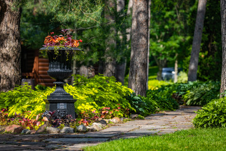 A beautiful urn planter vase overflowing with vibrant flowers at Munsinger Gardensの写真素材