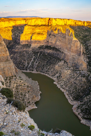 A breathtaking scenic view of a golden sunset from Devil's Canyon Overlook, casting a warm glow over...