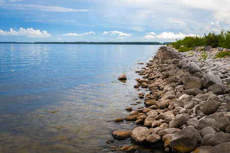 A vibrant display of colorful stones adorns the unique, fluctuating shoreline of Devils Lake, North Dakotaの写真素材