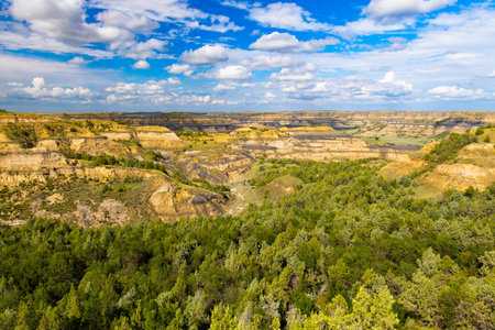 A sweeping panoramic view captures the dramatic landscapes along the Caprock Coulee Trail at Theodore Roosevelt National Parkの写真素材