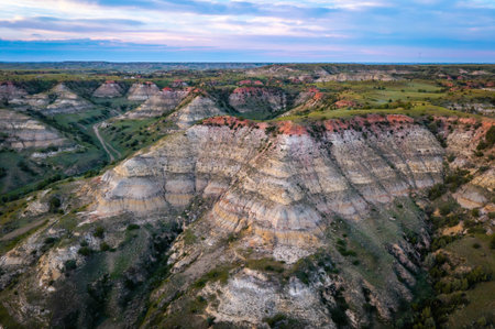 Scenic aerial view near Theodore Roosevelt National Park showcasing colorful Canyons at sunset sun