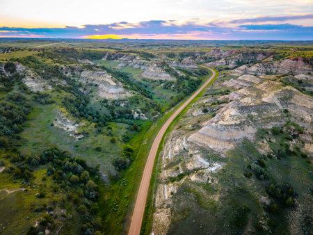Scenic aerial view near Theodore Roosevelt National Park showcasing colorful Canyons at sunset sun