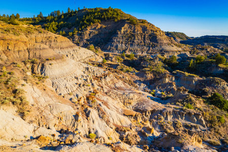 A dramatic sunset over the badlands formations of Makoshika State Park as seen from the Cap Rock Trailの写真素材