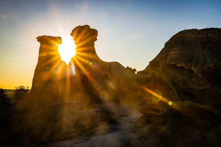 The iconic Twin Sisters rock formation silhouetted against a beautiful sunset sky at Makoshika State Parkの写真素材