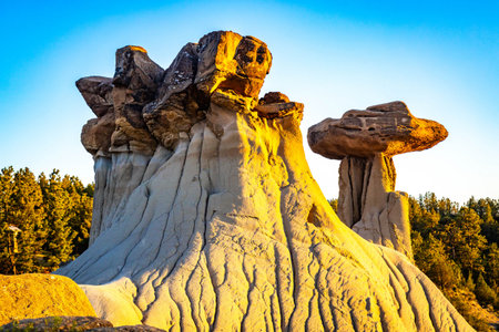 The iconic Twin Sisters rock formation silhouetted against a beautiful sunset sky at Makoshika State Parkの写真素材