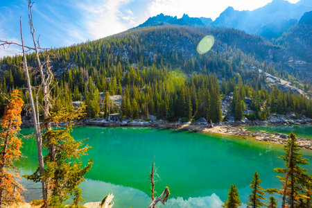 A scenic view captures the stunning, vibrant turquoise waters of Colchuck Lake, nestled within the Okanogan-Wenatchee National Forest in Washington.の写真素材