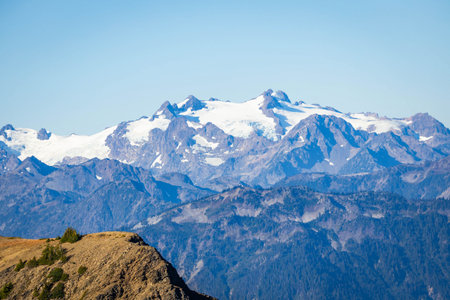A detailed, close-up panoramic view captures the massive, glacier-covered peak of Mount Olympus,...