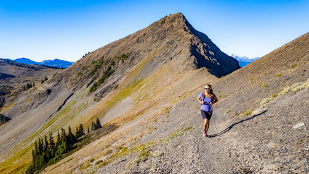 A happy female hiker is captured actively hiking on the scenic trail near the Obstruction Point...