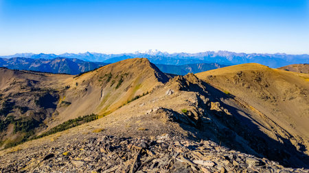 A vibrant view captures the majestic Grand Ridge mountains range bathed in the golden light of a...