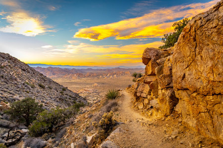 Mountain ranges stretch across the desert landscape during golden sunset hour from the top of Ryan...
