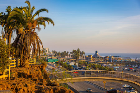 Los Angeles, CA, USA - December 01, 2025: Sunset light washes over the Santa Monica coastline and...