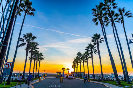 Los Angeles, CA, USA - December 01, 2025: Intense sunset colors glow behind silhouetted palm trees...