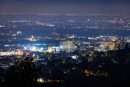 Scenic aerial view shows Hollywood city lights glowing at night in Los Angeles, California