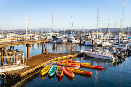 Monterey, CA, USA - November 24, 2025: Boats docked along Monterey Harbor Bay under clear sunny...