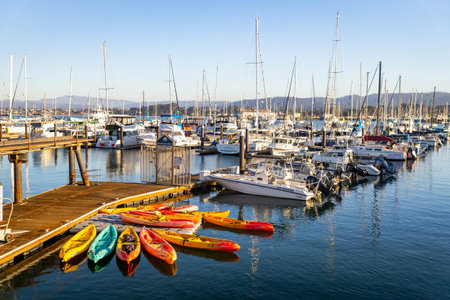 Monterey, CA, USA - November 24, 2025: Boats docked along Monterey Harbor Bay under clear sunny...