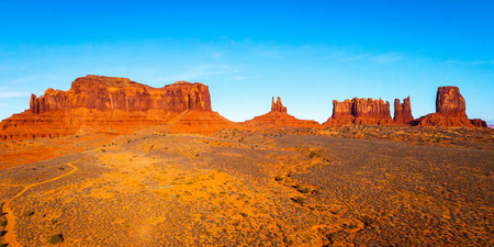 Scenic aerial view of sandstone buttes and desert landscape in North Monument Valley under sunset light