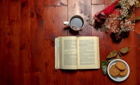 old book and cup tea on the wood backgroundの写真素材