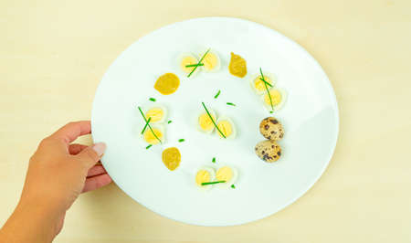 boiled quail eggs with mustard and chives on a plate
