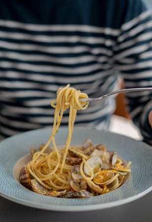 detail male hand eating pasta spaghetti with clams and mullet, Mediterranean foodの写真素材