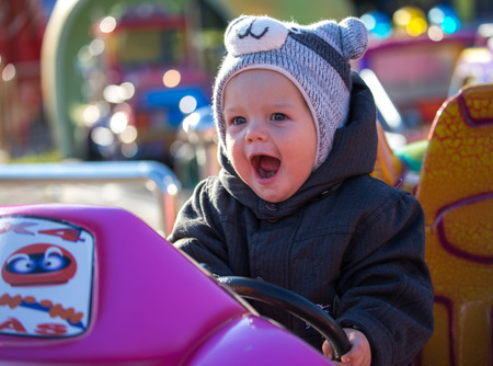 Happy little boy sitting in toy carの写真素材