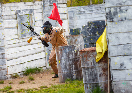 Armed man setting up victory flag in paintball missionの写真素材