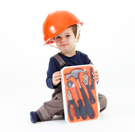 Little worker in orange helmet with tools kit on whiteの写真素材