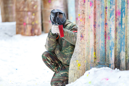 Paintball game in winter. Cool shooter behind fortification.の写真素材