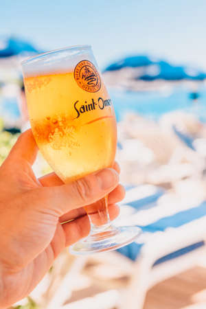 Nice, Provence / France - September 29, 2018: Man on the beach in a restaurant with a glass of beer in his handのeditorial素材